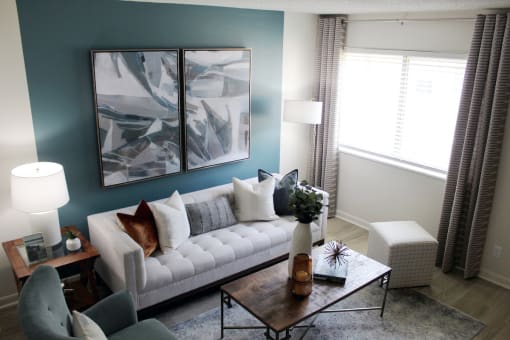 living room with large window, accent wall, and model furniture  at Huntsville Landing Apartments, Alabama, 35806