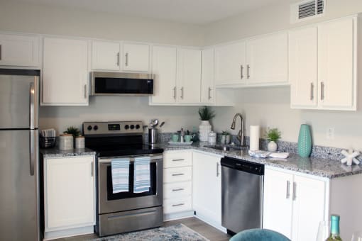 kitchen with white cabinets, granite countertops, and stainless steel appliances and built-in microwave  at Huntsville Landing Apartments, Huntsville, AL
