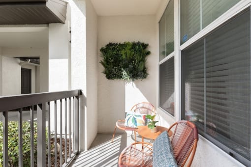 a patio with two chairs and a table on a balcony