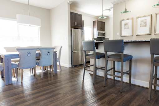 A kitchen with a table and chairs.