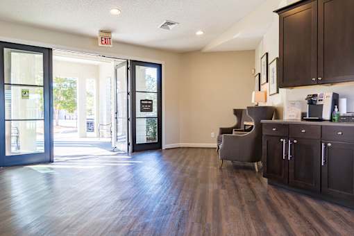 A room with a brown floor and a grey chair.