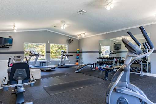 A spacious gym with treadmills, elliptical machines, and other exercise equipment.