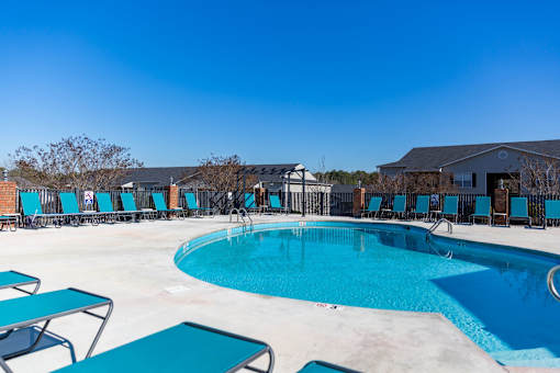 A large outdoor swimming pool surrounded by lounge chairs.