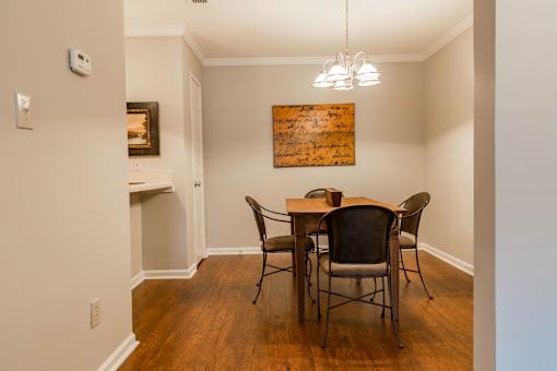 A dining room with a wooden table and chairs.