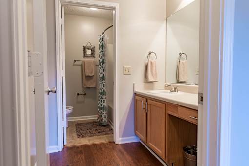 A bathroom with a towel hanging on the shower curtain.
