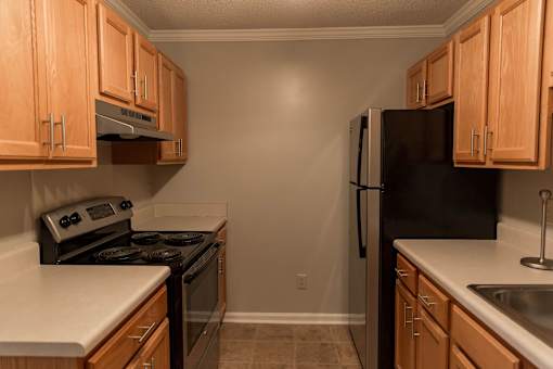 A kitchen with wooden cabinets and black appliances.