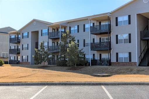 Apartment building with a parking lot in front.