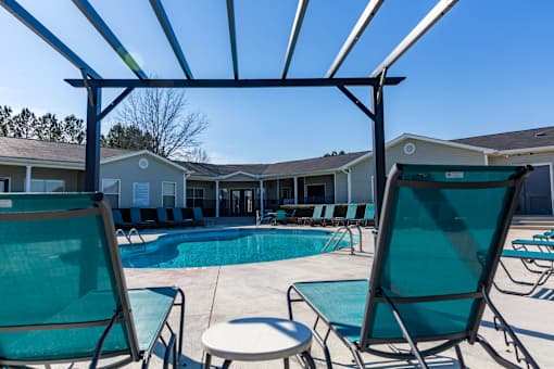A pool area with chairs and a canopy.