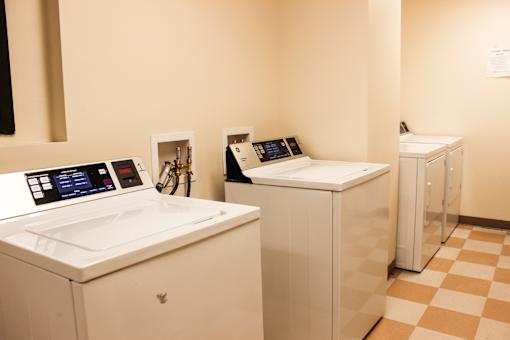 A row of white washing machines in a laundromat.