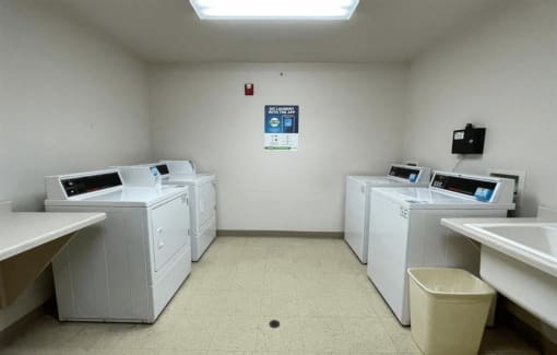 a group of washers and dryers in the laundry center at Algonquin Manor