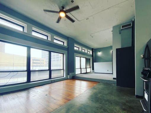 large windows in loft with ceiling fan and hardwood and concrete floors at Jemison Flats, Birmingham, AL, 35203
