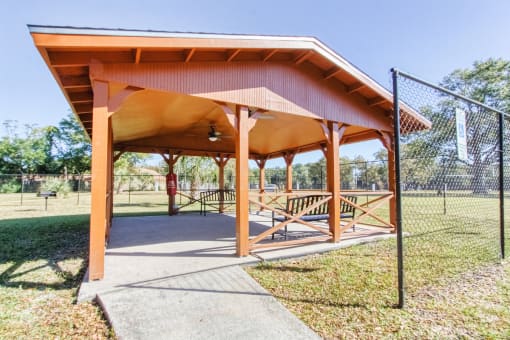 Outdoor pavilion with benches and a BBQ grill