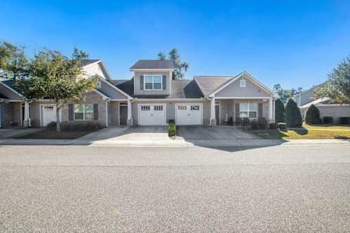 A row of houses with driveways in front.