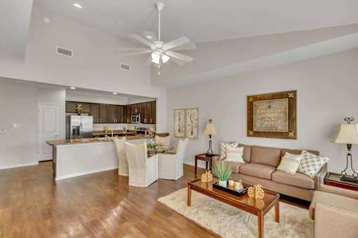 A living room with a brown couch and a wooden floor.