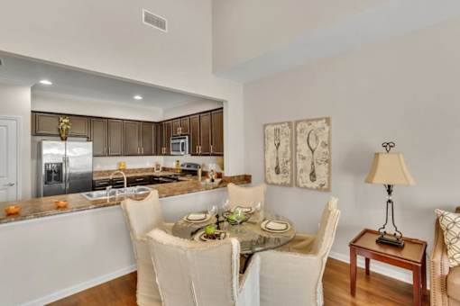 A modern kitchen with a dining table set for two.