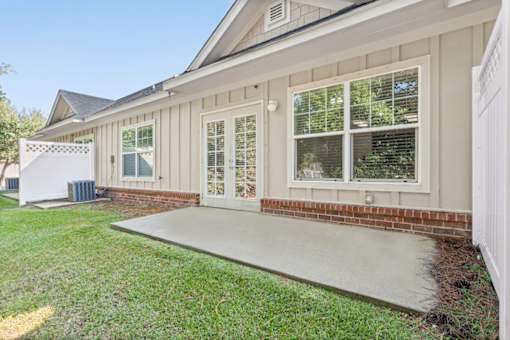 A house with a white fence and a covered patio.