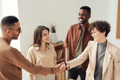 a diverse group of people shaking hands and smiling