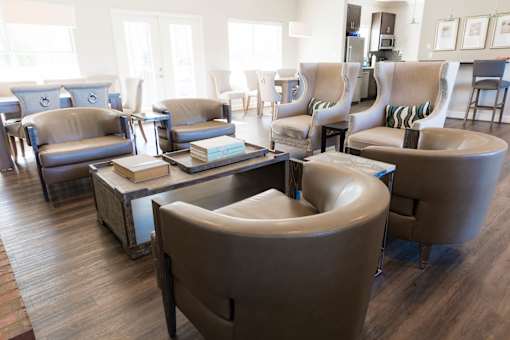 A living room with a variety of chairs and a coffee table.