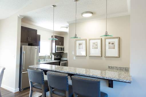 A kitchen with a granite countertop and a refrigerator.