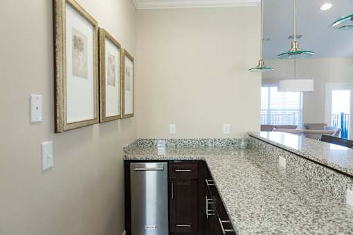 A kitchen with granite countertops and a stainless steel dishwasher.