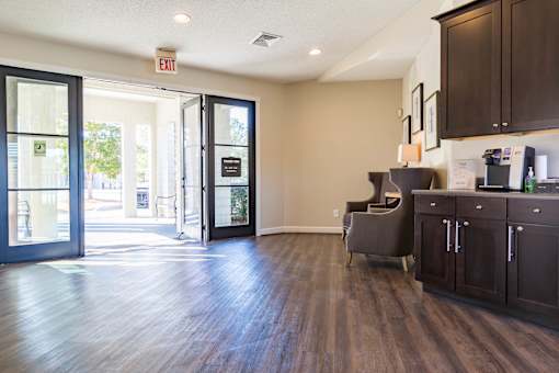 A room with a wooden floor and a grey chair.