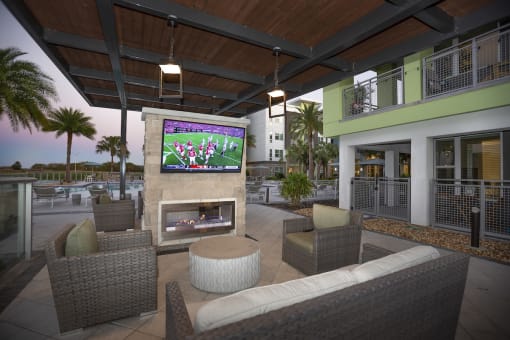 Outdoor TV and fireplace lounge poolside at The Residences at The Green in Lakewood Ranch, Florida