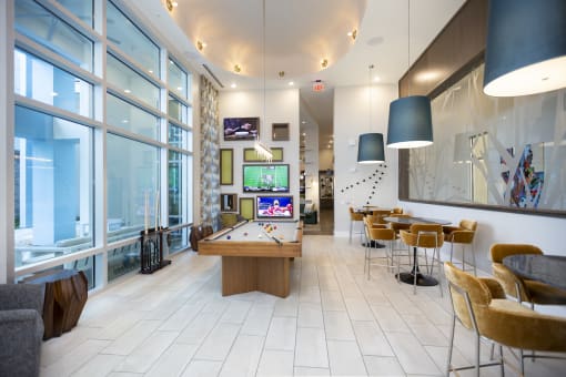 Game room with TVs, pool table, and lounge style seating at Residences at The Green