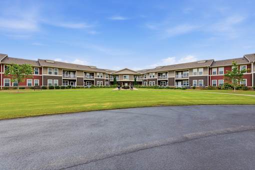 A large apartment complex with a parking lot in front.