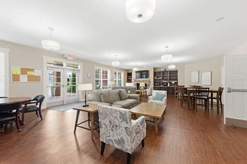 A spacious living room with a variety of furniture including a couch, chairs, and a coffee table.