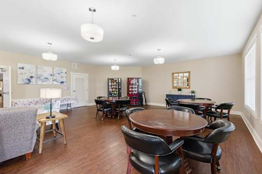 A living room with a couch, chairs, and a dining table.