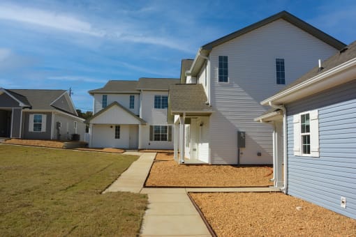 a row of newly built houses, neat sidewalks, and green grass at The Sanctuary at Indian Creek