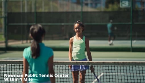 two young women playing tennis on a tennis court