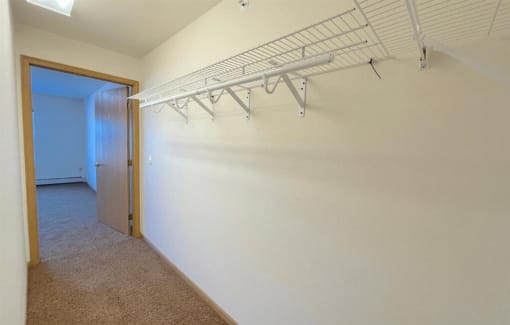 a large walk-in closet with built-in wire shelving in an Algonquin Manor Apartment home