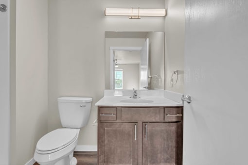 a bathroom with a sink toilet and a mirror