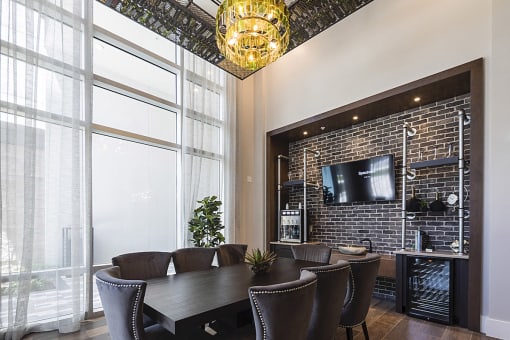 Wine tasting room with wine chandelier, tv, and table with chairs at Residences at The Green in Lakewood Ranch, FL