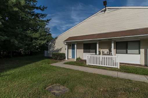 A house with a white picket fence and a tree in the front yard.