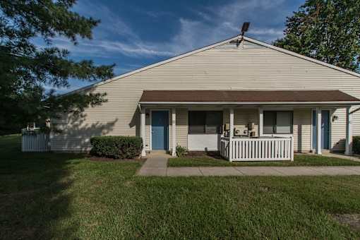A house with a brown roof and a white fence.