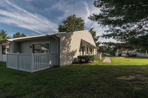 A house with a grey roof and a white fence.