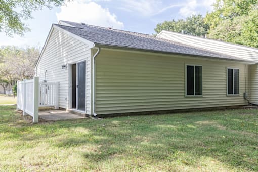 apartment building exterior showing patio surrounded by a white fence