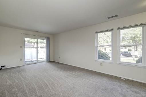 a bedroom with a sliding glass door and a carpeted floor