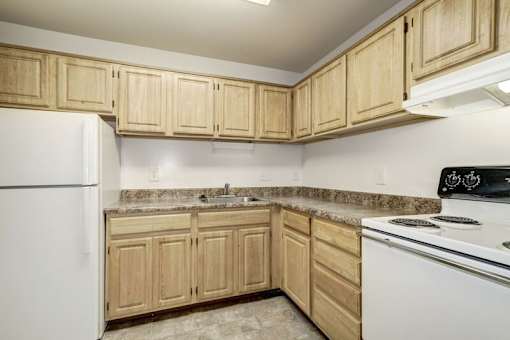 a kitchen with wooden cabinets and white appliances