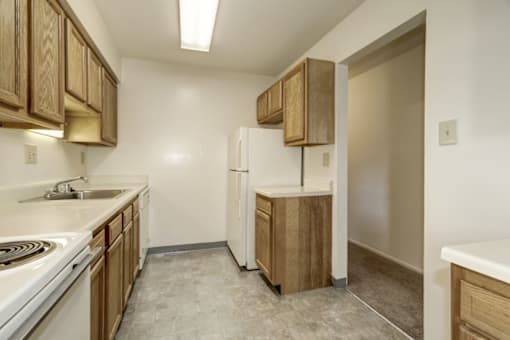 a kitchen with white appliances and wooden cabinets