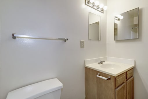 bathroom with white countertops and wood cabinetry