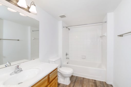 Bathroom with tiled shower and large mirror with vanity lighting