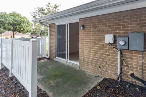a white fence in front of a brick building