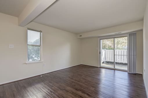 a living room with hardwood floors and a sliding glass door to a patio