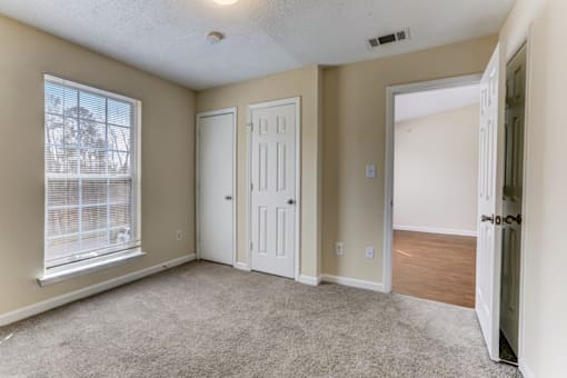 an empty living room with an open door and a window