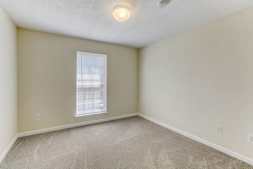 an empty room with carpet and a window