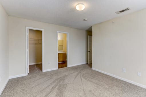 an empty living room with an open door to a bathroom