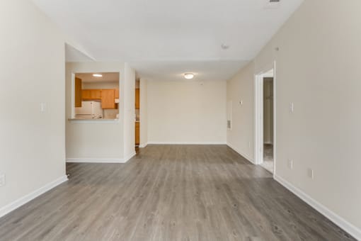 an empty living room with white walls and wood flooring